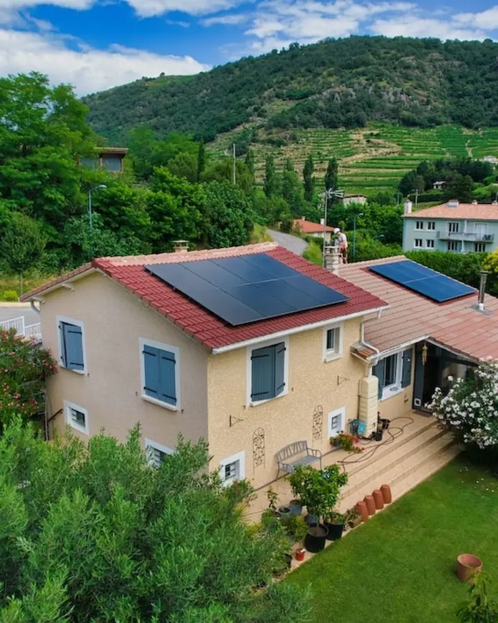 Vue aérienne d'une maison avec panneaux solaires sur toit en tuiles rouges